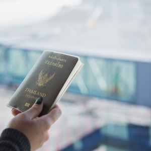 Travel concept. Closeup of woman hand holding Thai passport ready to boarding..